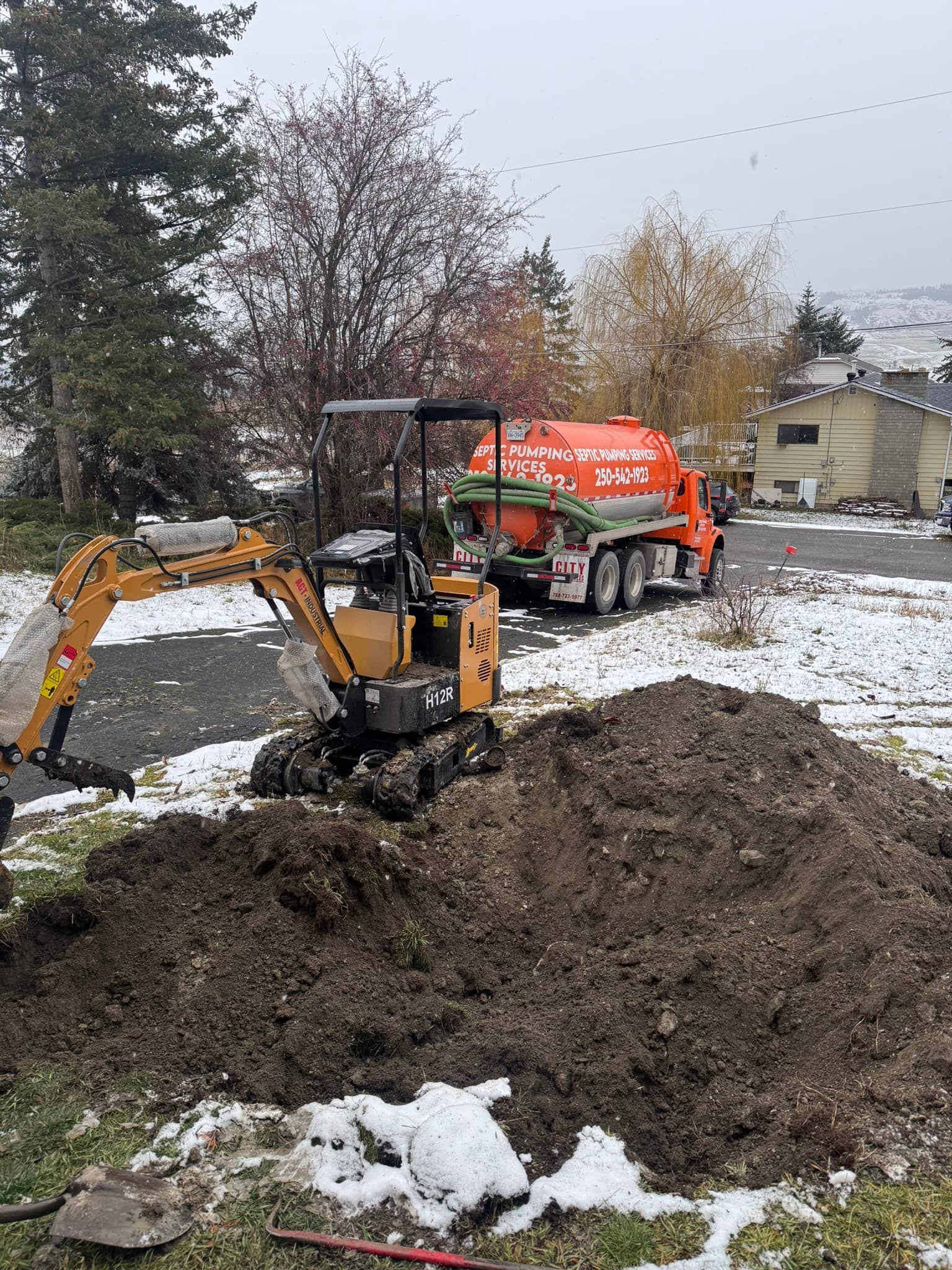 Septic installation work with pump truck and excavation equipment